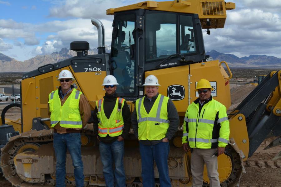 four construction workers in front of equipment